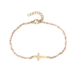 Bracelet croix en métal doré avec entrelacement de perles de couleur rose